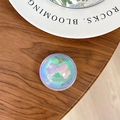 Macro view of a round iridescent phone grip holder featuring a pink 3D bow decoration - Dreamy Bubble No. 37