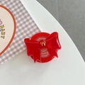 Makro-Detail des roten 3D-Schleife-Handyhalters aus Harz mit goldenem Akzent in der Mitte - Rot