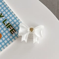 Detalle de soporte para móvil con lazo blanco crema y corazón dorado en base clara - Lazo Grande Corazón Francés Blanco