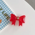Detail of red bow phone grip with gold heart accent on white tabletop background - Large Bowknot French Heart Red