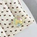 Close-up of the crystal ball phone grip with a yellow bow on a quilted fabric pad - Crystal Ball Holder-Dreamy Bubble-No.63 Matte Yellow Bow