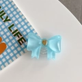 Detail of light blue bow phone grip with golden heart relief on a clean desk - Large Bowknot French Heart Blue