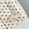 Close-up of a holographic crystal ball phone grip with pink bow inside on quilted fabric - Crystal Ball Holder-Dreamy Bubble-No.67 Matte Pink Bow