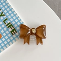 Macro detail of brown bow phone grip with vintage gold heart relief on white desk - Large Bowknot French Heart Brown