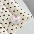 Close-up of a pink bow inside a glittery crystal ball phone grip on a quilted fabric - Crystal Ball Holder-Dreamy Bubble-No.68