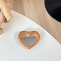 Detail of heart-shaped phone grip mirror with orange tortoiseshell pattern on wood - Orange (Splatter Heart Mirror)