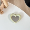 Detail of cream heart phone grip with speckled stone texture and functional mirror surface - Light Yellow (Splatter Heart Mirror)