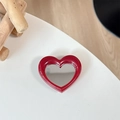 Detail view of heart-shaped dark red makeup mirror with polished finish on white surface - Red (Splatter Heart Mirror)