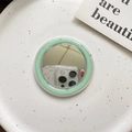 Detail of mint green MagSafe mirror phone accessory on a white ceramic tray - Dark Green