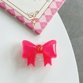 Close-up of rose pink resin bow phone grip with glossy finish and gold emblem - Rose Red