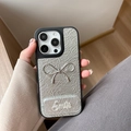 Close-up of silver wrinkled leather iPhone case with a 3D metallic bow and Smile detail - Silver