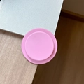 Close-up of pink matte magnetic phone socket stand on wooden desk near a laptop - Deep Pink