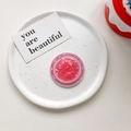 Detail of pink shell pattern Magnetic MagSafe phone grip on a white ceramic tray - Magnetic Model / Cherry Red