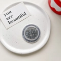 Macro shot of circular MagSafe phone grip with grey marble texture on a white plate - Magnetic Model / Black