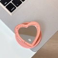 Dettaglio del supporto a specchio per telefono a cuore rosa glitterato su un laptop - Arancione