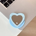 Close-up of heart-shaped glitter phone grip with selfie mirror on laptop background - Blue