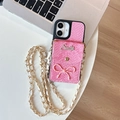 Detalle de funda rosa con textura de serpiente, pequeño monedero, logo Smile y cadena - Patrón de Serpiente de Agujero Grande - Cartera de Lazo Smile - Cadena de Cuero / iPhone 17 Pro Max / Rosa Roja