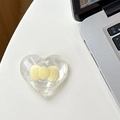 Detailed close-up of a transparent heart-shaped Magsafe phone grip with yellow bow decoration - Adhesive-Yellow