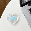 Detail showing a heart-shaped MagSafe phone grip with a light blue bow on a white desk - Adhesive - Blue