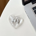 Detail of transparent heart MagSafe phone grip with silver bow accent on a desk - Adhesive-Silver