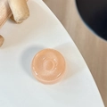 Makroansicht einer schimmernden Pfirsich-Harz-Halterung mit perlmuttartiger Glitzertextur - Donut-Halterung - Perlglanz - Orange