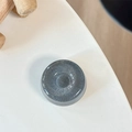 Nahaufnahme einer grauen MagSafe-Handyhalterung mit glitzerndem Sternenhimmel-Effekt - Donut-Halterung - Perlglanz - Schwarz