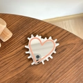 Detail van hartvormige spiegel telefoonhouder met roze rand op houten bureau - Transparante Standaard - Egel Hart Spiegel - Oranje