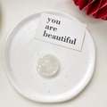 Macro detail of shell texture phone grip on white ceramic plate with card - Shell Pattern Grip - Iridescent White
