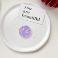 Detailed top view of a round purple marble textured pop socket on a ceramic plate - Shell Pattern Grip - Purple