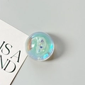 Macro shot of holographic shell-shaped phone grip with glitter on grey background - Dreamy Bubble No. 12