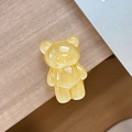 Close-up of a translucent bright yellow glittery bear phone grip on a wooden desk - Standard Pop Socket Style / Pearlescent Bear - Yellow
