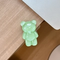 Close-up of a light green glittery resin bear phone grip on a minimalist wooden desk - Standard Pop Socket Style / Pearlescent Bear - Dark Green