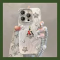 Detail van glitter kerstboomhoesje voor iPhone met luxe parel polsbandje aan - Ster Kerstboom met Parel Diamantketting / iPhone 17 Pro Max