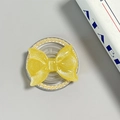 Detail of yellow glitter bow phone grip with pearl border and MagSafe magnetic base - Pearl Magnetic Style / Yellow