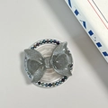 Detail showing glitter bow Magsafe phone grip with dark blue pearl accents and clear base - Pearl Magnetic Style / Silver Grey