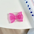 Close-up of a pink glitter bow MagSafe phone grip with a sparkling resin finish - Pearl Adhesive Style / Rose Red