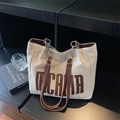 Cremefarbene Canvas-Tote mit dunkelbraunem NICAVA-Print und Kunstleder-Kettenriemen - Braun