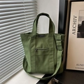 Forest green canvas tote bag with adjustable strap and front zipper pocket detail - Green