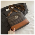 Close-up of brown monogram bucket bag with patterned strap and metal M logo detail - Coffee