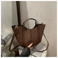 Detail view of brown leather bucket bag with top handles and adjustable shoulder strap - Coffee