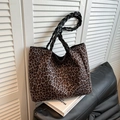 Leoparden-Tote-Bag mit gewebten Schultergurten vor einem minimalistischen Innenhintergrund - Braun