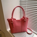 Rosa Lederbeutel Handtasche mit goldener Hardware und Schultergurt im natürlichen Sonnenlicht - Rosa