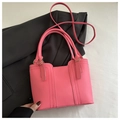 Close-up of vibrant pink tote bag with gold hardware and vertical stitching details - Pink