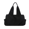 Minimalist black nylon tote bag with integrated shoulder straps and side pockets on white back - Black