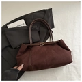 Détail macro du sac cabas en daim marron foncé avec fines bretelles et boucle dorée - Marron