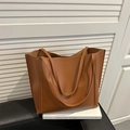 Grande borsa tote marrone minimalista con doppi manici appoggiata su libri bianchi - Marrone