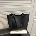 Grande borsa tote minimalista in pelle nera opaca da donna presentata in studio pulito - Nero