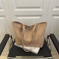 Large beige suede tote bag with leather handles displayed on a black chair for commuting - Khaki