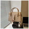 Detail of minimalist beige mini handbag featuring silver buckle and smooth leather texture - Khaki