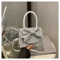 Macro detail of silver sequined mini bag with a large bow and white leather handle - Silver